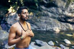 een man die mediteert voor een rivier