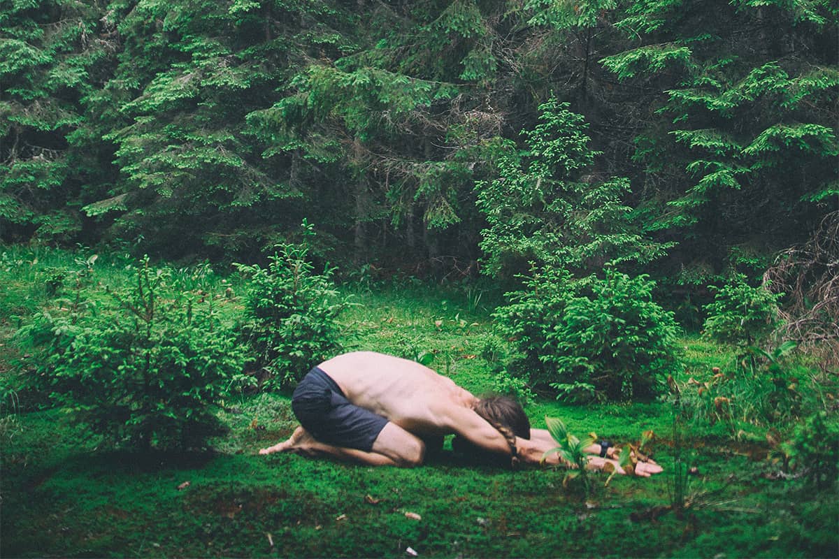 Een man die yoga in een bos beoefent