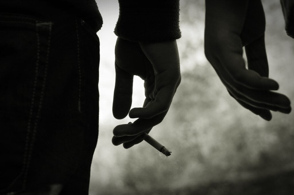 a person holding a cigarette in a hand
