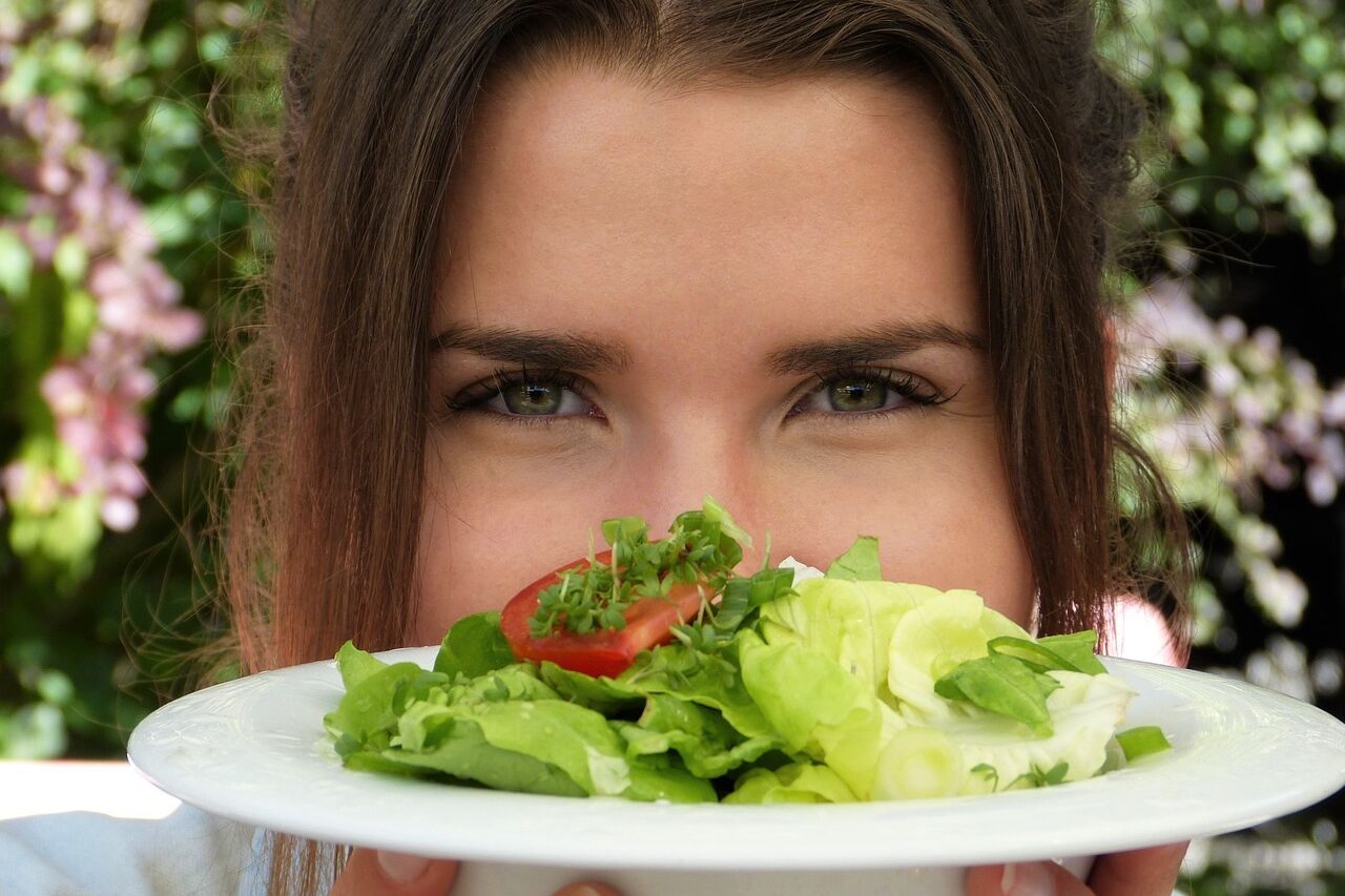 women holding a plate of salad